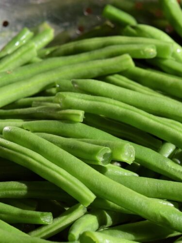 close up of green beans in a colander