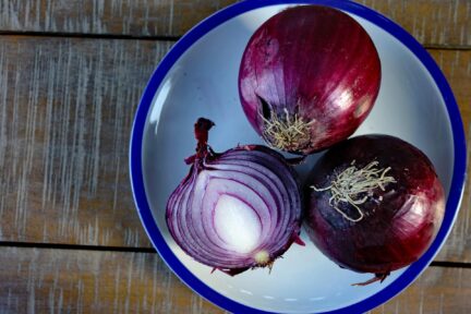 Picture of some red onions and one of them is cut up