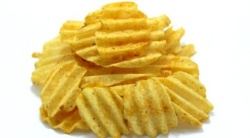 Closeup of crinkle cut potato chips with a white background