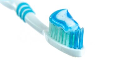 closeup of toothpaste on toothbrush with white background