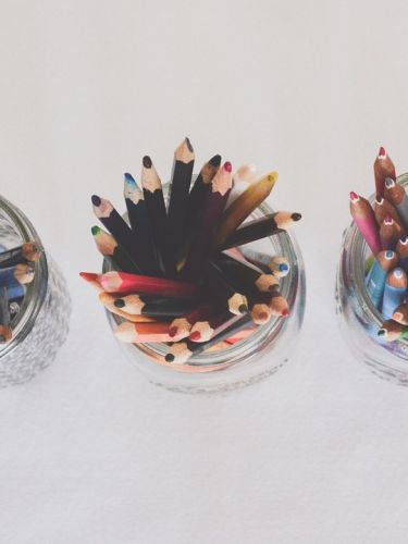 Above view of 3 jars filled with colored pencils