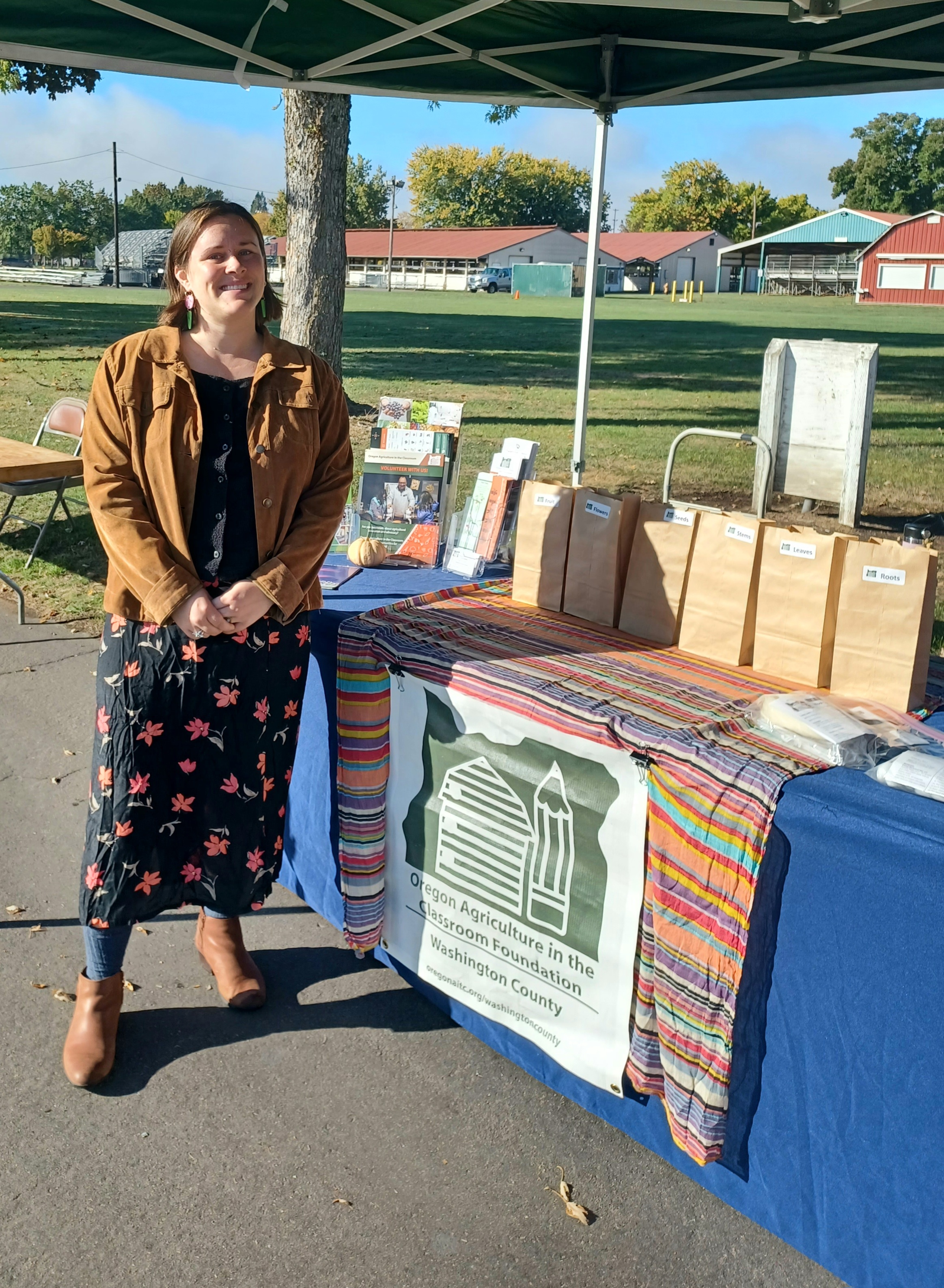 A person stands in front of a table that has brochures and other pieces of paper on it